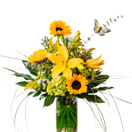 Yellow lilies and sunflowers in a clear glass vase