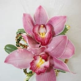 Pink orchid corsage with ribbon and small green accents