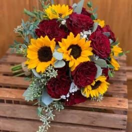 Bouquet of red roses and yellow sunflowers with eucalyptus