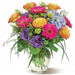 Mixed bouquet of bright flowers in a clear glass vase