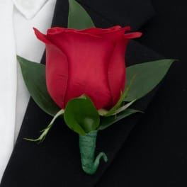 Red rose boutonniere with green leaves on a black suit lapel
