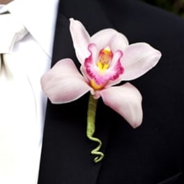 Pink orchid boutonniere pinned to a black suit jacket