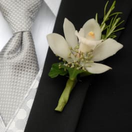 White orchid boutonniere pinned to a black suit jacket