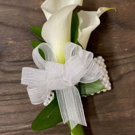 White calla lily corsage with a sheer ribbon bow and pearl accents