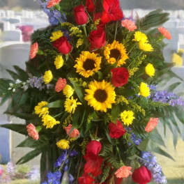 Standing floral spray with red roses, sunflowers, and purple flowers
