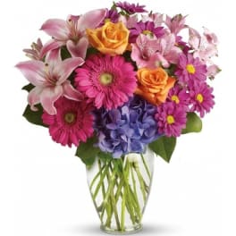 Mixed pink and purple flowers in a clear glass vase