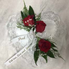 Heart-shaped lace pillow with red roses and a white ribbon