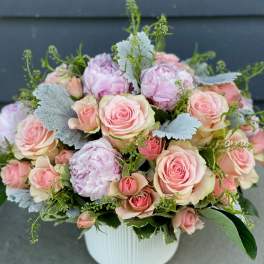 Pink roses and peonies arranged in a white vase