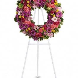 Colorful floral wreath on a white easel stand