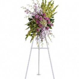 Standing floral spray with purple flowers on a metal easel