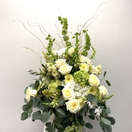 Tall white and pale yellow floral arrangement with roses and daisies
