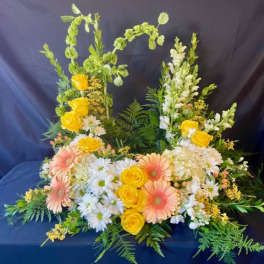 Floral arrangement with yellow roses, peach gerbera daisies, and white daisies