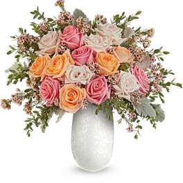 Bouquet of pink, peach, and white roses in a white vase