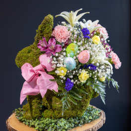 Moss-covered bunny-shaped floral arrangement with pink ribbon and pastel flowers