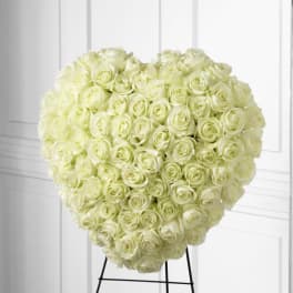 Heart-shaped bouquet of pale white roses on a stand
