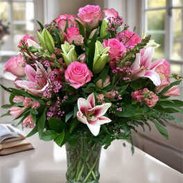 Pink roses and lilies arranged in a glass vase