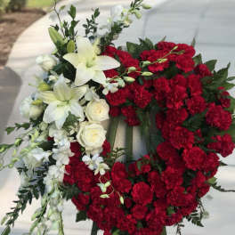 Red and white floral funeral wreath on an easel