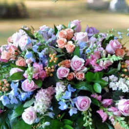 Large pastel floral arrangement with pink roses and blue flowers
