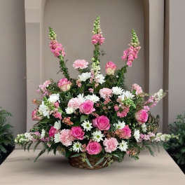 Large basket arrangement of pink roses, carnations, and white daisies