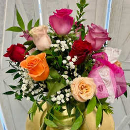 Mixed roses in a gold vase with baby's breath and greenery