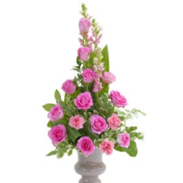 Pink roses and carnations arranged in a gray vase