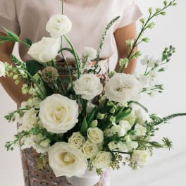 Woman holding a white bouquet of roses and mixed blooms
