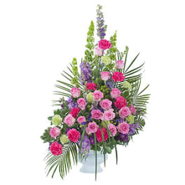 Tall pink and purple floral arrangement in a white vase