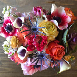 Mixed bouquet with pink anemones, roses, calla lilies, and blue thistle