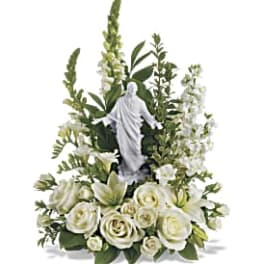 White floral arrangement with a religious statue centerpiece