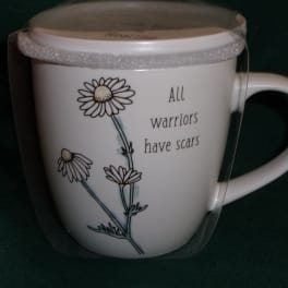 White mug with daisy illustration and the words "All warriors have scars"