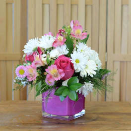 Pink and white mixed bouquet in a square glass vase