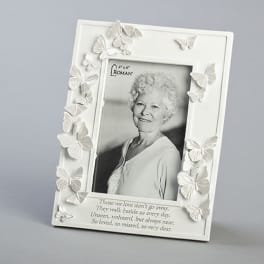 White memorial photo frame decorated with butterflies and a portrait inside