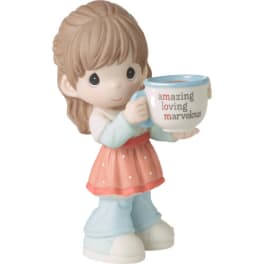 Small figurine of a girl holding a mug with text