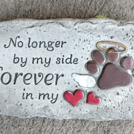 Memorial stone with a paw print, wings, and the words "Forever in my side"