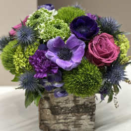 Bouquet of purple, pink, and green flowers in a birch-style box