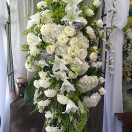 Tall white floral standing spray with lilies and roses