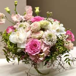 Pink and white roses arranged in a white vase