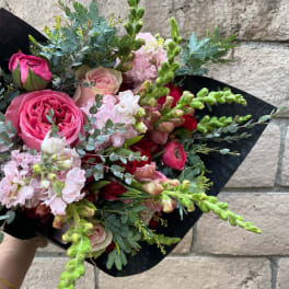 Pink and red mixed bouquet wrapped in black paper