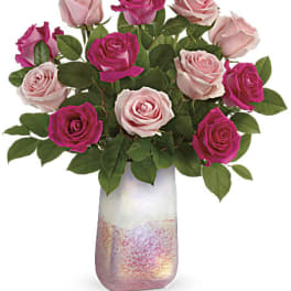 Pink and magenta roses in a frosted glass vase