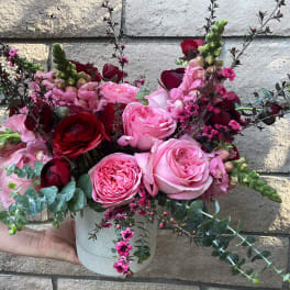 Pink and red rose arrangement in a white vase