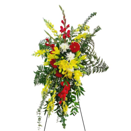 Standing floral spray with red, yellow, and white flowers on an easel