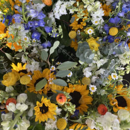 Mixed bouquet with sunflowers, blue delphinium, and white blooms
