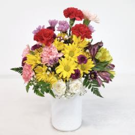 Mixed bouquet of carnations, daisies, and alstroemeria in a white vase