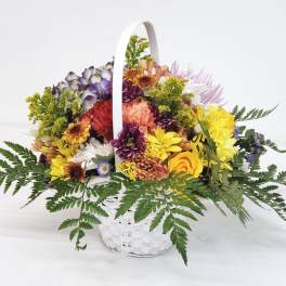 Mixed flower basket with a white handle and colorful blooms