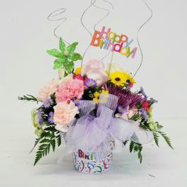 Birthday flower arrangement with a colorful topper and lavender bow