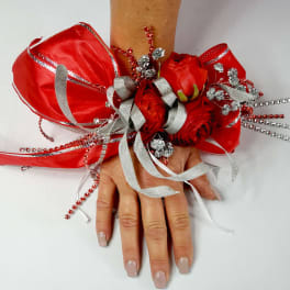 Red rose wrist corsage with silver ribbon and beaded accents
