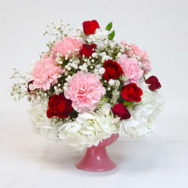 Pink and red flower arrangement in a pink vase