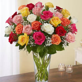 Mixed bouquet of multicolored roses in a clear glass vase