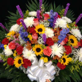 Large mixed bouquet with sunflowers, white blooms, and a white ribbon bow