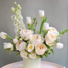 Cream bouquet with tulips and roses in a white vase